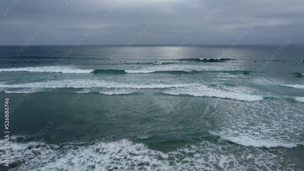 La Jolla Beach, California on a Cloudy Day with Surfers enjoying the Waves La Jolla Beach, California on a Cloudy Day with Surfers enjoying the Waves