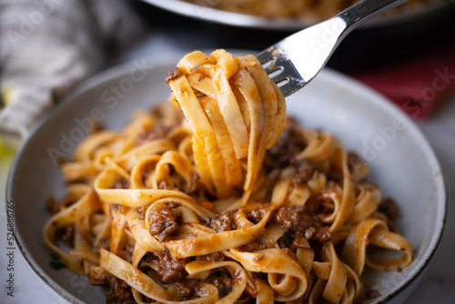 lifting up fettuccine ragu with fork