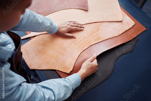 Konstfotografi Close up of craftsman working with genuine leather pieces on table in tannery sh