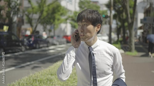 忙しそうに街を電話しながら歩くビジネスマン