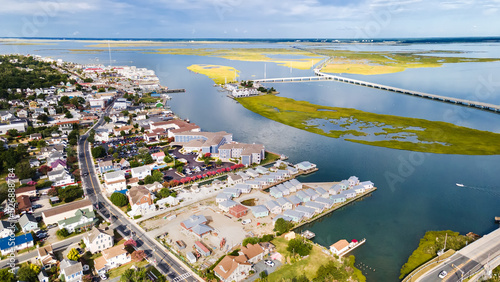 Chincoteague Island, marinas, houses and motels with parking lots. bridge and road along the bay. Drone view.