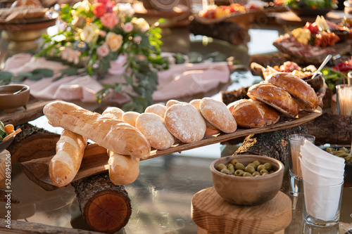 Pan sobre troncos de madera y aceitunas mesa elegante y charcutería
