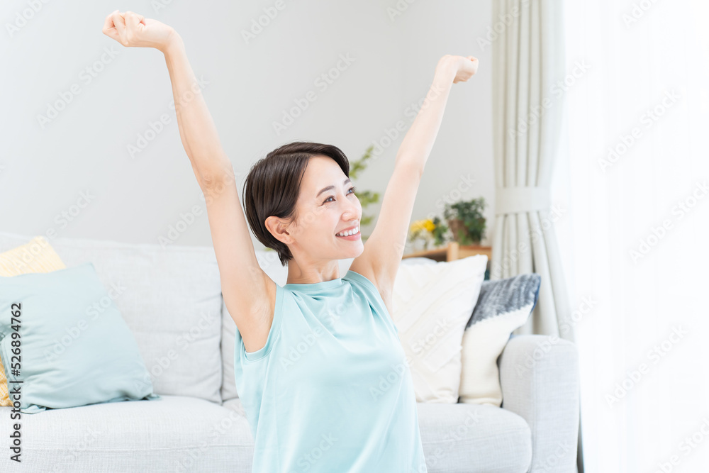 自宅で伸びをする日本人女性