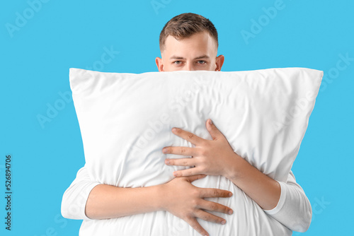 Young man with pillow on bl...