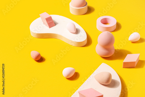 Makeup sponges with decor on yellow background