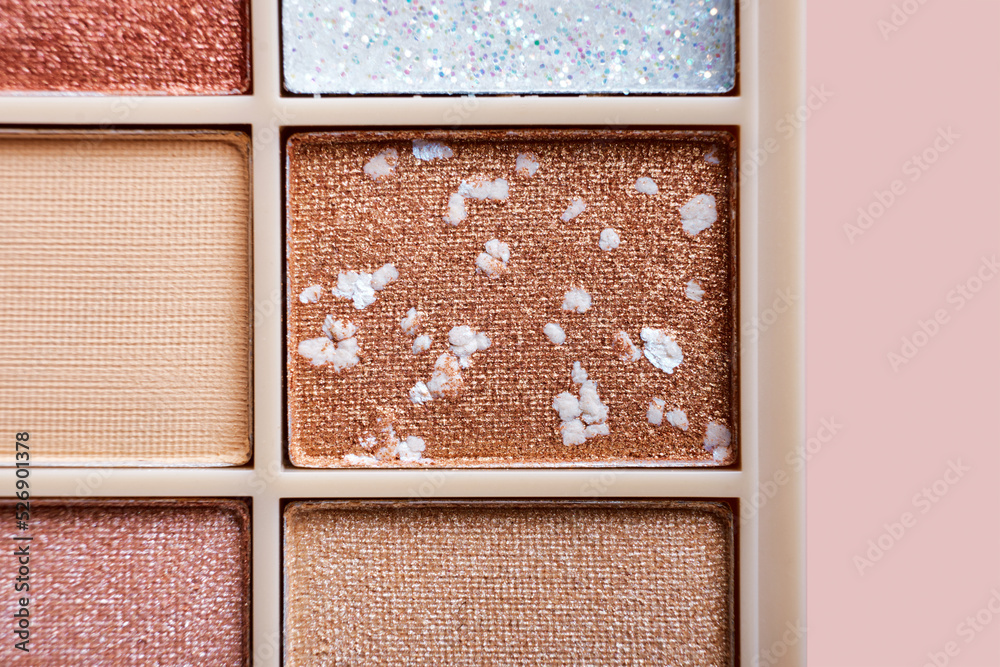 Fototapeta premium Eyeshadow colorful shades palette in beige tones close-up. Beauty abstract background