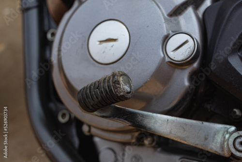 The motorcycle gear lever is bent from the impact.