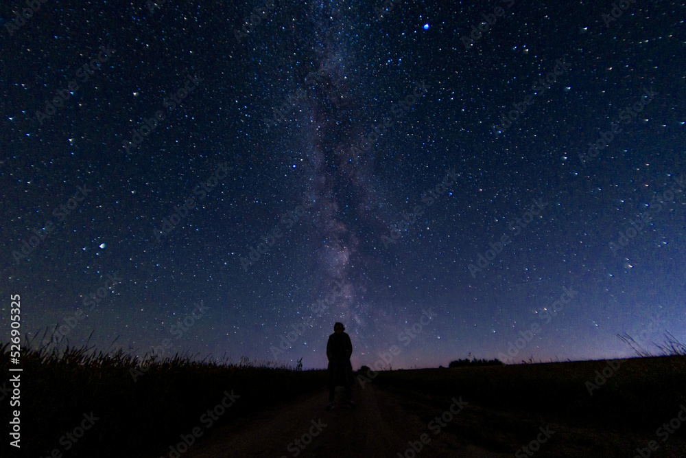 lonely silhouette of a man against the background of the night sky with stars and the milky way.