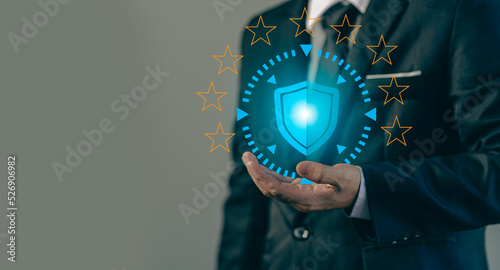 .Businessman holding a shield with stars around it for global network connectivity and network security. insurance business internet fire wall and cybercrime data protection