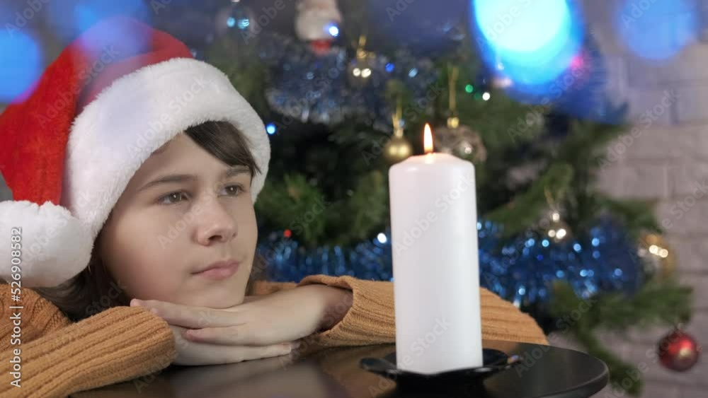 Dreaming teen by Christmas candle. A view of dreaming teen girl by the fire on big candle in the Christmas decorated room. Dreaming teen by Christmas candle. A view of dreaming teen girl by the fire on big candle in the Christmas decorated room.