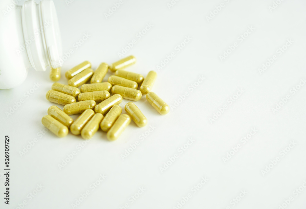 Vitamins for the eyes - lutein complex. Yellow capsules on a white background with a white bottle. Vitamins for the eyes - lutein complex. Yellow capsules on a white background with a white bottle.