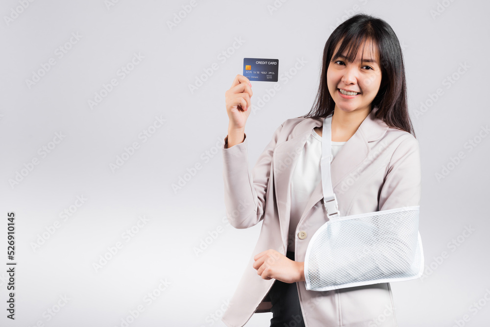 Woman confident smile broken arm after accident and wear arm splint for treatment she emergency pay medical bills by credit card, Happy Asian female sling support hand isolated on white background Woman confident smile broken arm after accident and wear arm splint for treatment she emergency pay medical bills by credit card, Happy Asian female sling support hand isolated on white background