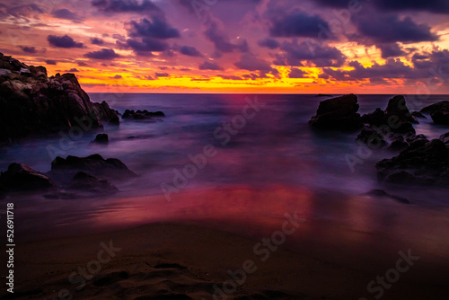 sunset on the beach with red colors, purpple clouds and orange sky in coast of puerto escondido oaxaca 