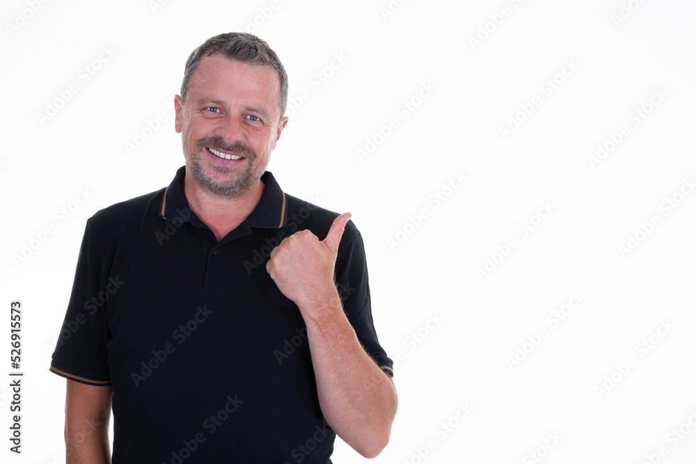middle aged businessman wearing black polo standing over isolated white background smiling with happy face looking and pointing to the side with thumb up middle aged businessman wearing black polo standing over isolated white background smiling with happy face looking and pointing to the side with thumb up