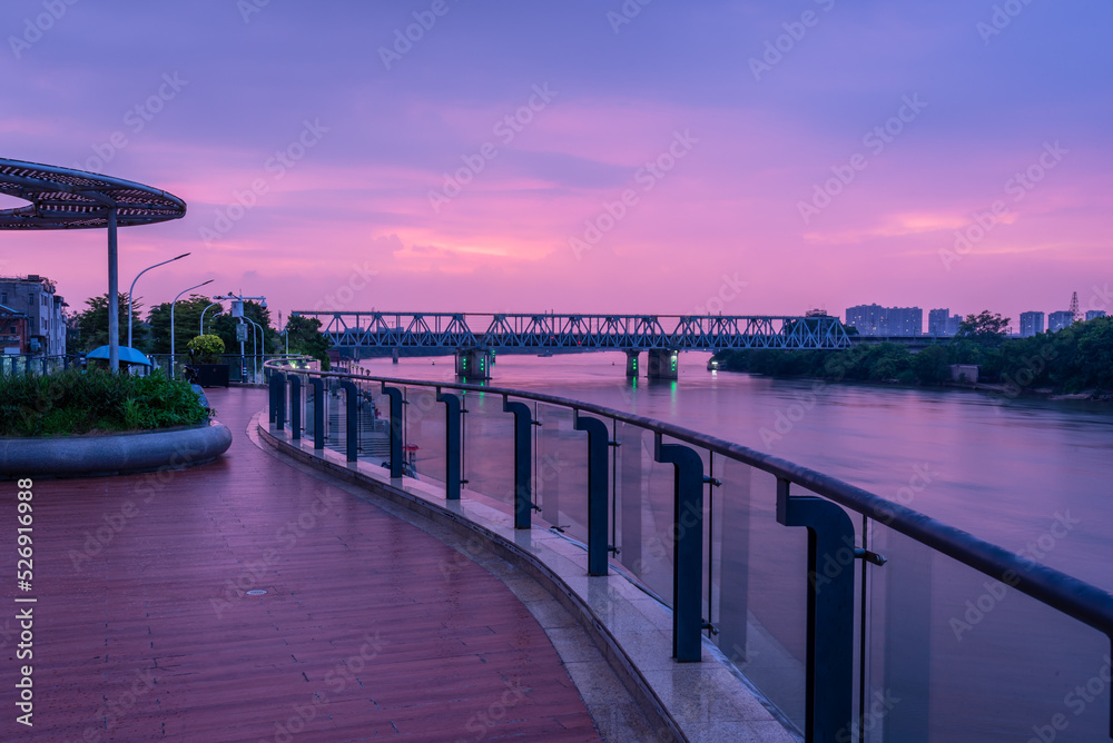 Cityscape of Shilong South Bank Park in Dongguan, China. Plank road on the second floor and Guangzhou-Shenzhen Railway at sunset. Landscape of Bank of Dong river in summer.