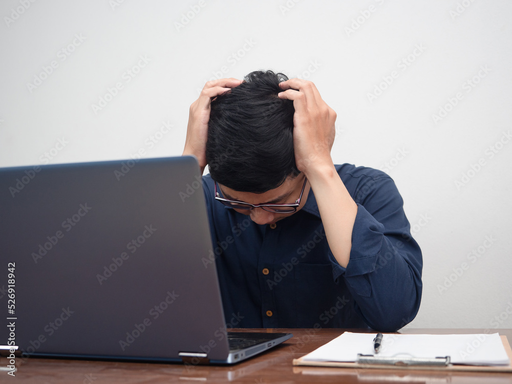 Businessman sitting at working table hold his head feels headache about work Businessman sitting at working table hold his head feels headache about work