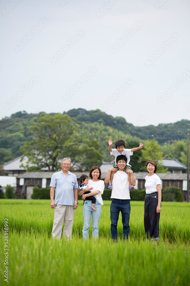 Obraz premium 夏休み 故郷に帰省した三世代家族の集合写真 田舎のあぜ道で撮影