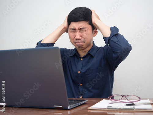 Male employee sit at working table feels headache with work