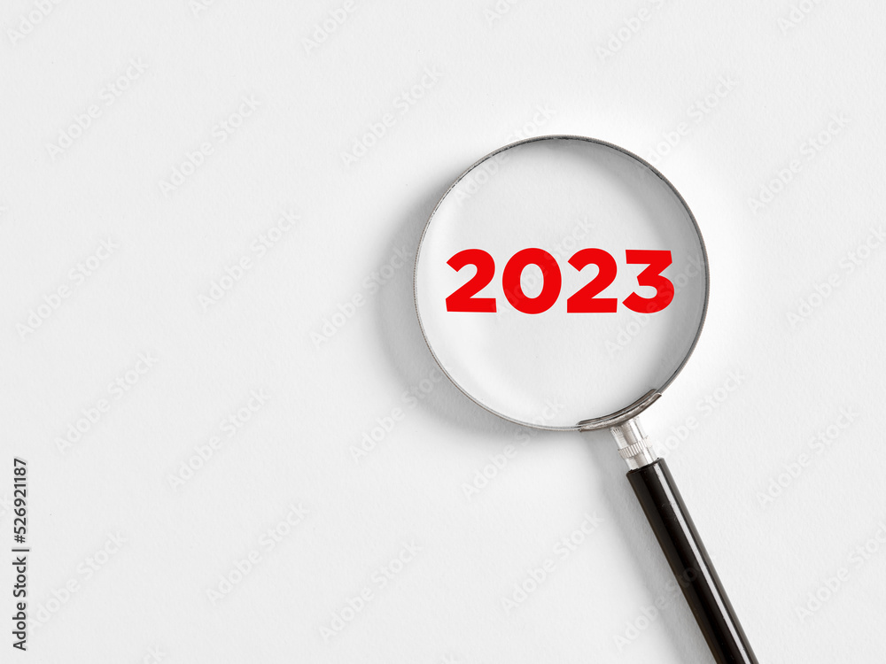 Magnifying glass magnifies the year 2023 on white background. Focusing on the year 2023 for business planning Magnifying glass magnifies the year 2023 on white background. Focusing on the year 2023 for business planning