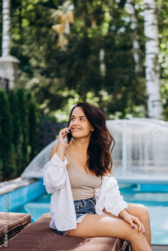 Woman talking on phone white relaxing in luxury resort hotel © Roman