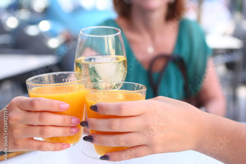 Φωτογραφία cold orange juice and wine glass with white wine in human hands clink glasses cl