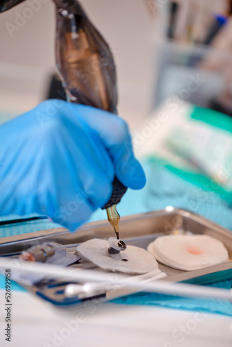 Tattoo Concept. Work Accessories and Tools for Tattoo Cosmetologist Preparing For Permanent Makeup Procedure In Beauty Salon. photo