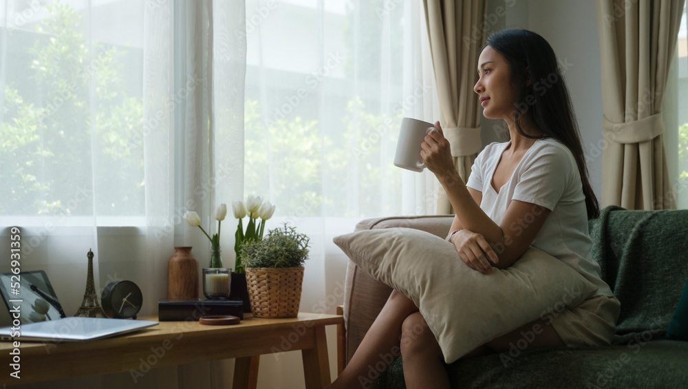 Relaxed young woman sitting on sofa and drinking hot coffee, enjoying weekend at home. Relaxed young woman sitting on sofa and drinking hot coffee, enjoying weekend at home.