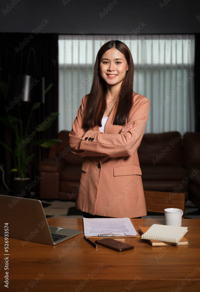 Confident businesswoman standing with arms crossed in contemporary office and smiling to camera. Confident businesswoman standing with arms crossed in contemporary office and smiling to camera.