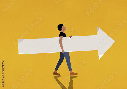 Man carrying paper arrow on yellow background
 photo