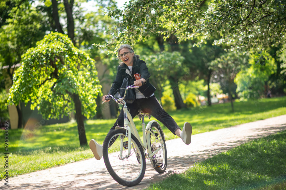 A woman in black clothes riding a bike and having fun