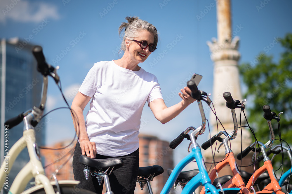 Obraz premium A woman in sportswear paying for bike rent online