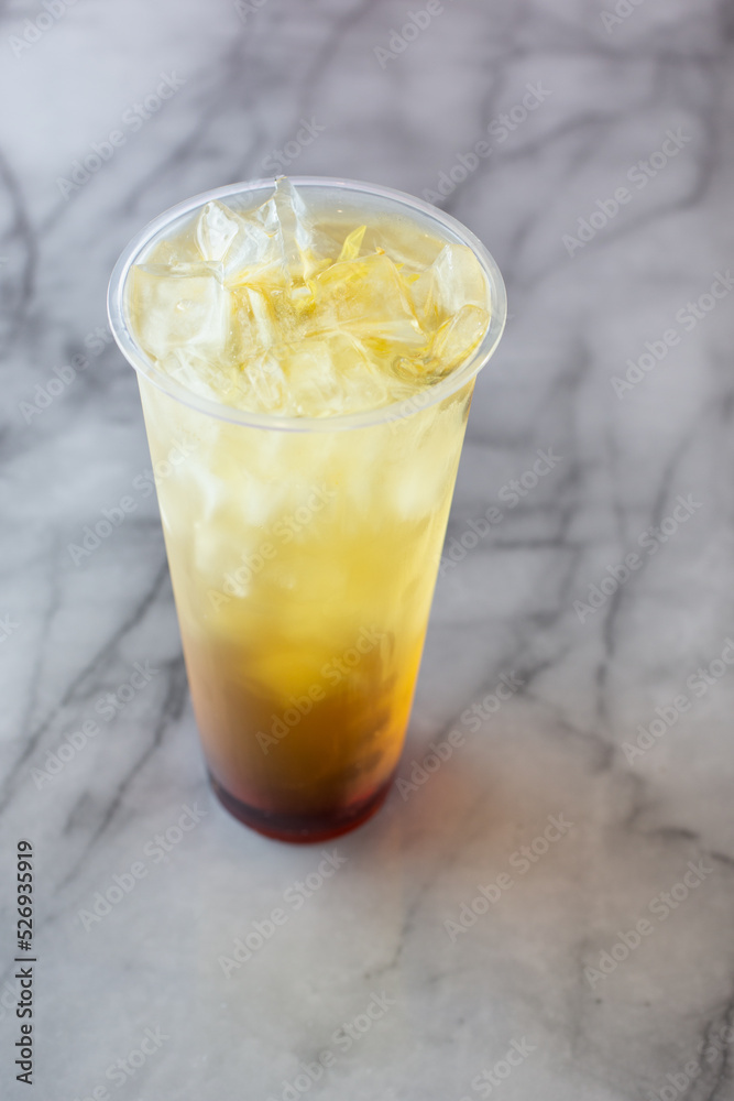 A view of a layered chrysanthemum fruit tea beverage. A view of a layered chrysanthemum fruit tea beverage.