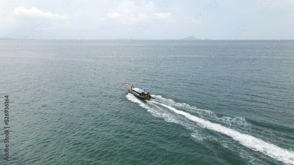 Aerial view of a fastmoving Thai hopping tour boat traveling in Andaman sea carrying tourists, Thailand Aerial view of a fastmoving Thai hopping tour boat traveling in Andaman sea carrying tourists, Thailand