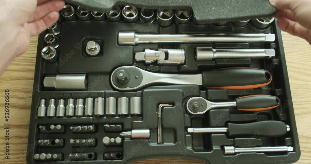 Man closes a plastic case with a set of ratchet sockets, socket wrenches, bits. A set of tools. First-person view Man closes a plastic case with a set of ratchet sockets, socket wrenches, bits. A set of tools. First-person view