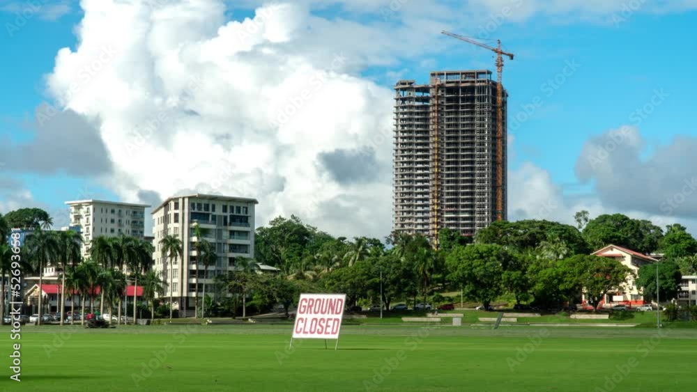 Albert Park in Suva city with tall skyscraper under construction, cumulus clouds, ground closed
