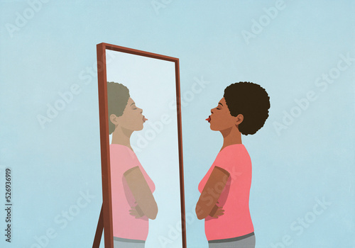 Woman sticking tongue out at mirror
