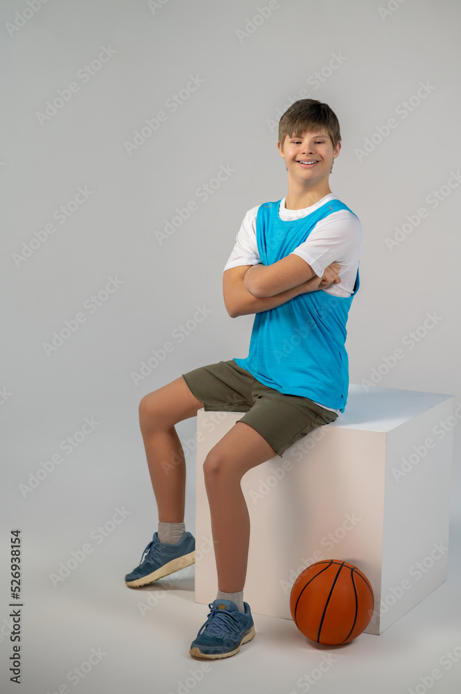 A contented boy sitting on a cube and smiling A contented boy sitting on a cube and smiling