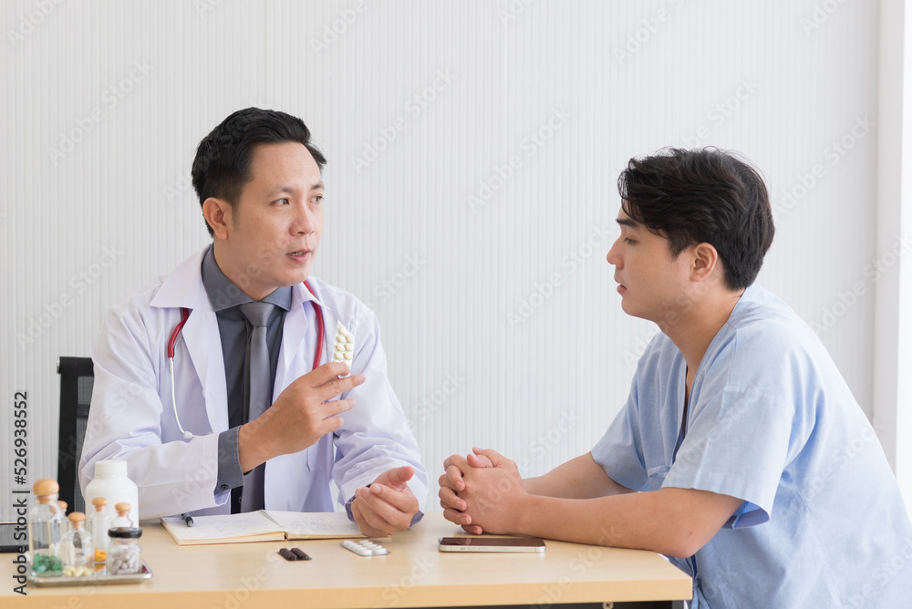 Asian doctor in professional work uniform discuss and explain symptoms to his patient. Asian doctor in professional work uniform discuss and explain symptoms to his patient.