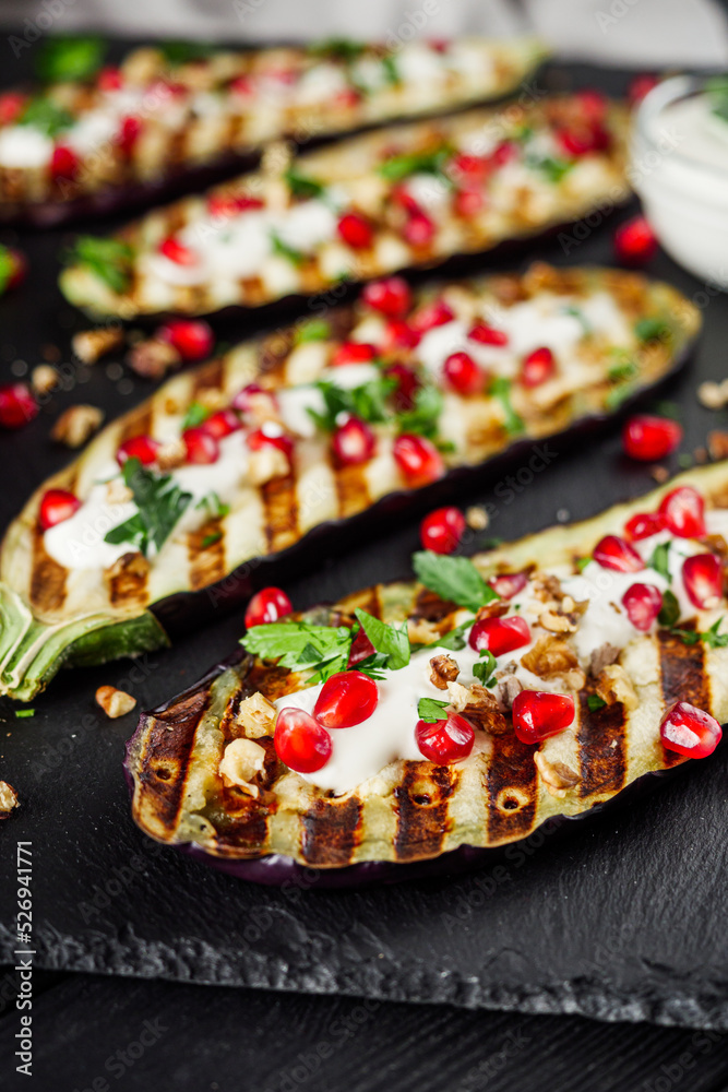 grilled eggplant in Georgian style on a black dark wooden rustic background