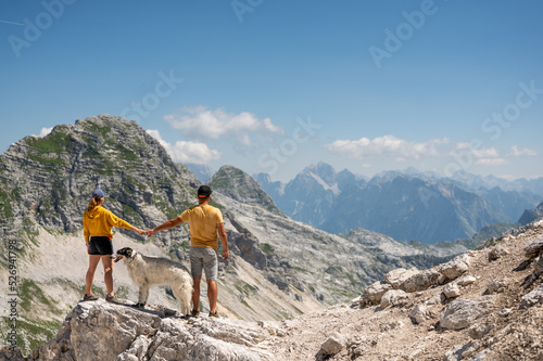 Couple enjoy the view of Slovenian mountains with Russian wolfhound dog