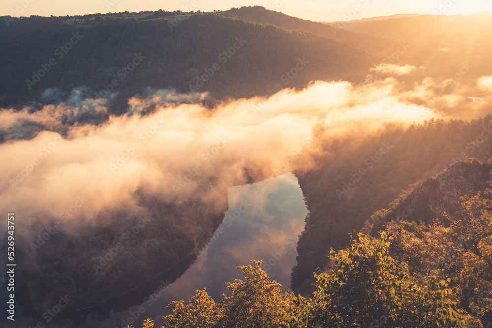 Fototapeta premium A Queuille en Auvergne, le belvédère modestement appelé le “Paradis”. Celui-ci donne sur la rivière Sioule qui forme le méandre de Queuille. vue à l'aube au lever du soleil avec de la brume