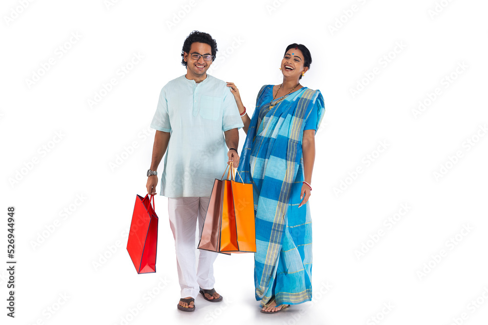 Happy Bengali couple standing with shopping bags Happy Bengali couple standing with shopping bags