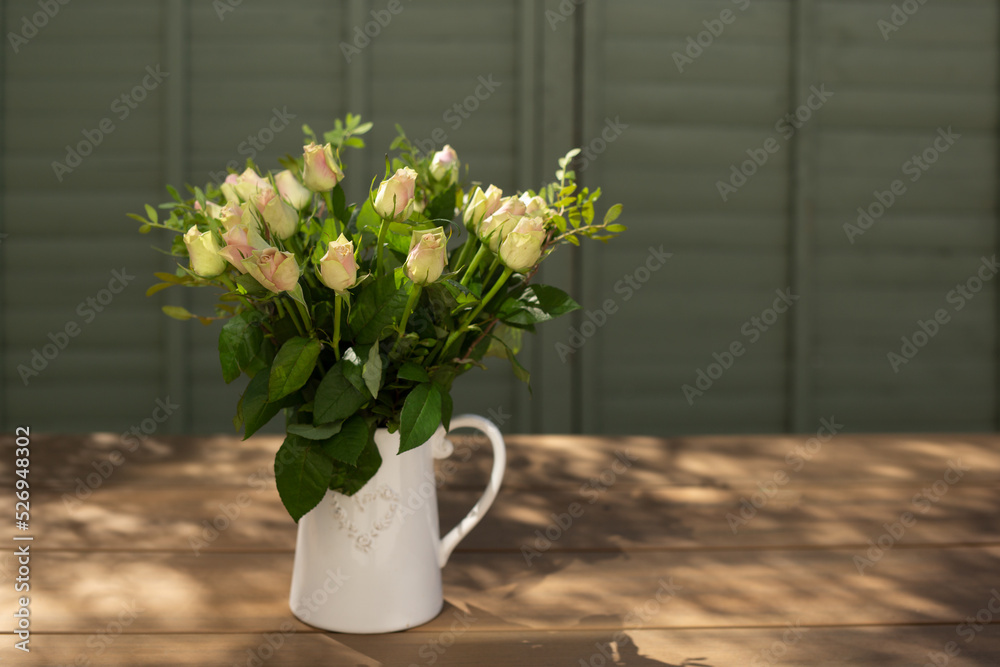 A bouquet of roses in a white jug A bouquet of roses in a white jug