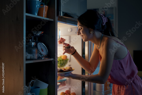 Hungry woman eating sweets at night