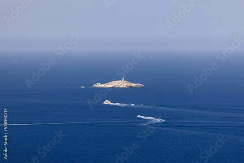 Ships cross the waters of Tyrrhenian Sea between the islands of the Tuscan archipelago, in the center of the picture is one of its tiniest with Faro dello Scoglietto di Portoferraio. Island of Elba photo