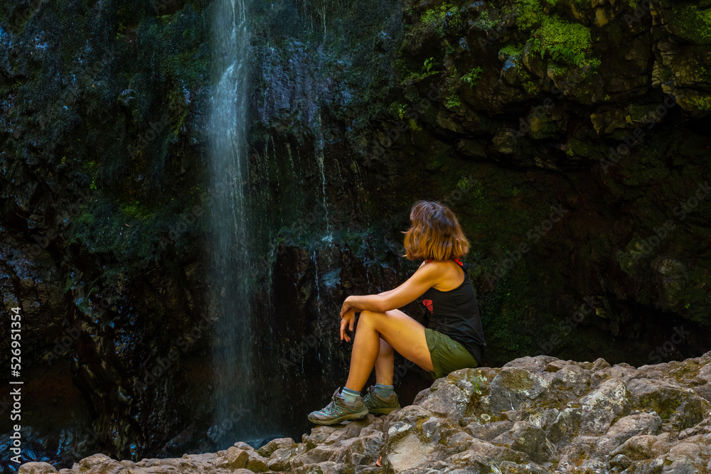 Unrecognizable young woman sitting in the waterfall at the Levada do Caldeirao Verde, Queimadas, Madeira Unrecognizable young woman sitting in the waterfall at the Levada do Caldeirao Verde, Queimadas, Madeira