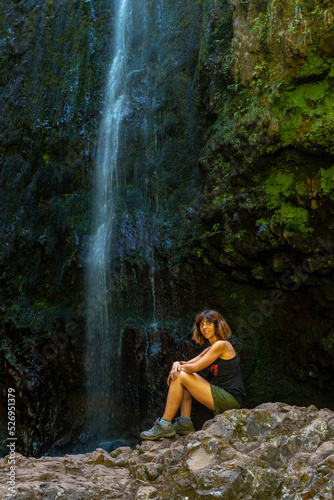 A young woman at the waterfall at the end of the waterfall trail at Levada do Caldeirao Verde, Queimadas, Madeira