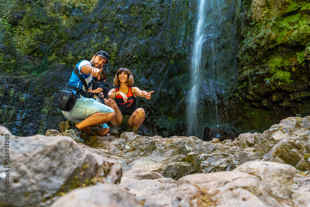 A family with their child in summer at the waterfall at Levada do Caldeirao Verde, Queimadas, Madeira