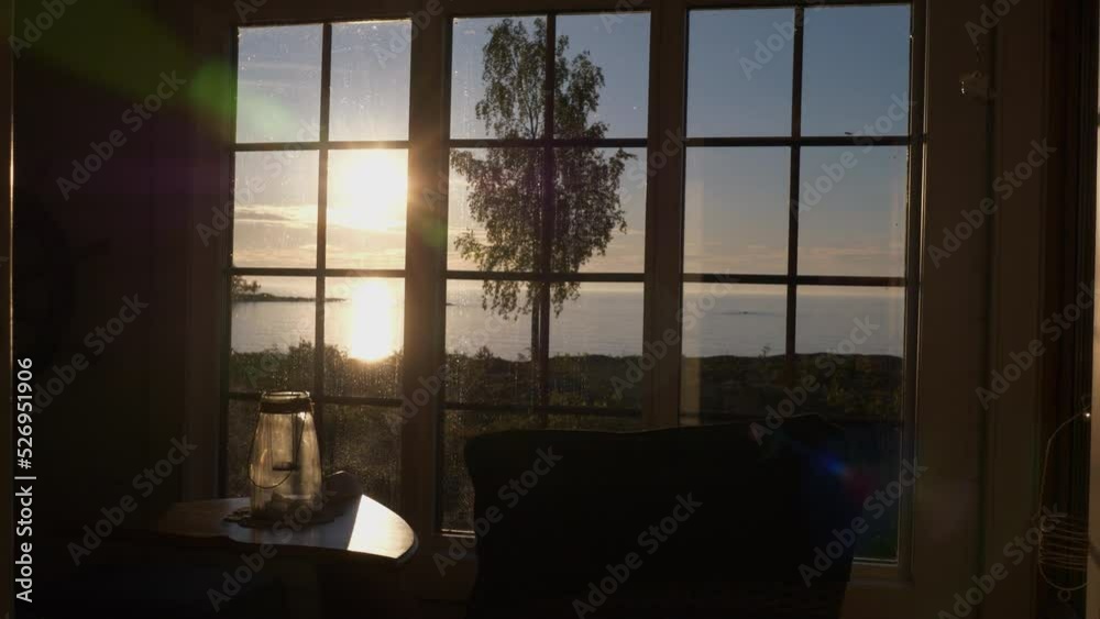 Handheld medium shot of sunset from inside cabin by the sea Handheld medium shot of sunset from inside cabin by the sea