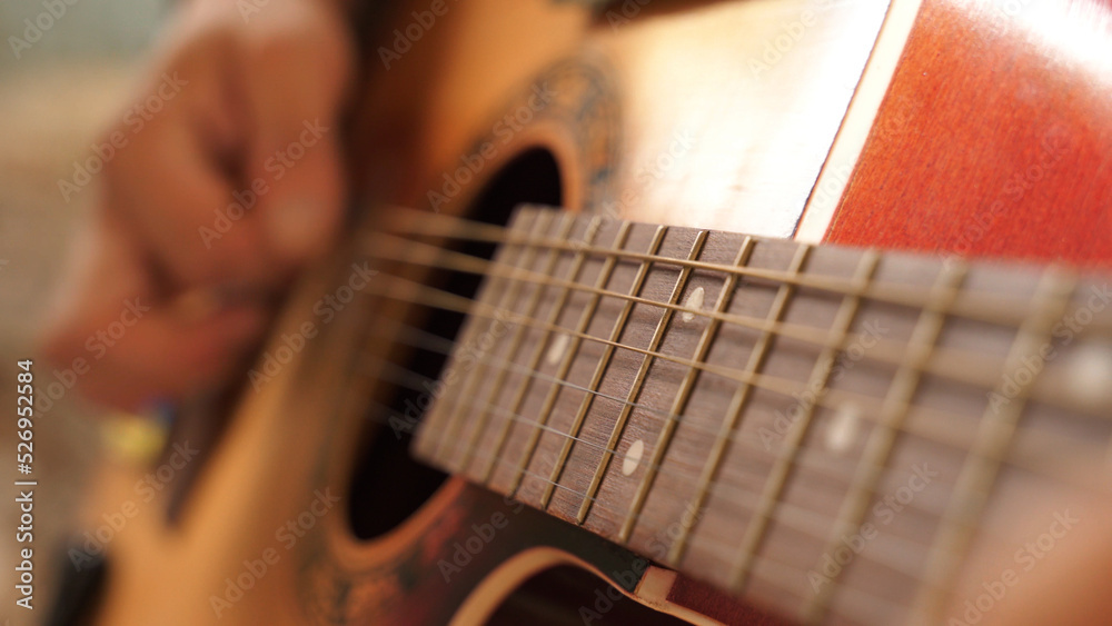 a Ukrainian military man in a camouflage uniform plays an acoustic guitar, strumming chords. close-up, rest after battle, music in war. military hobby. an infantryman writes a song after being on duty a Ukrainian military man in a camouflage uniform plays an acoustic guitar, strumming chords. close-up, rest after battle, music in war. military hobby. an infantryman writes a song after being on duty